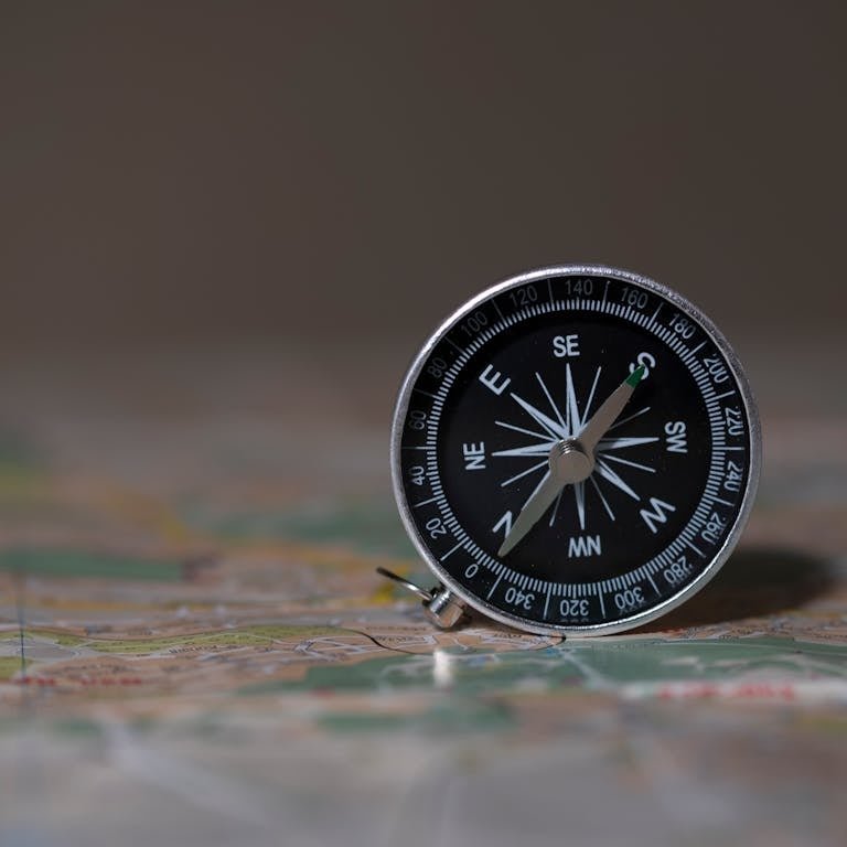 A detailed image of a compass on a map, symbolizing navigation and exploration.