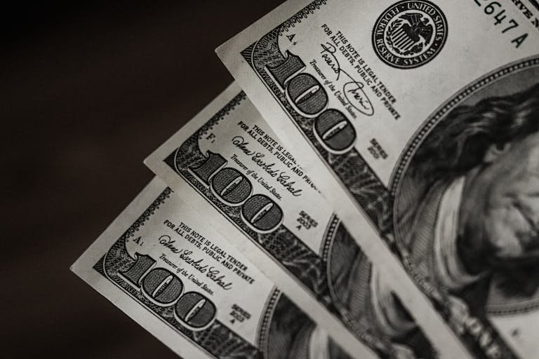Detailed close-up image of US hundred dollar bills arranged in a fanned pattern.