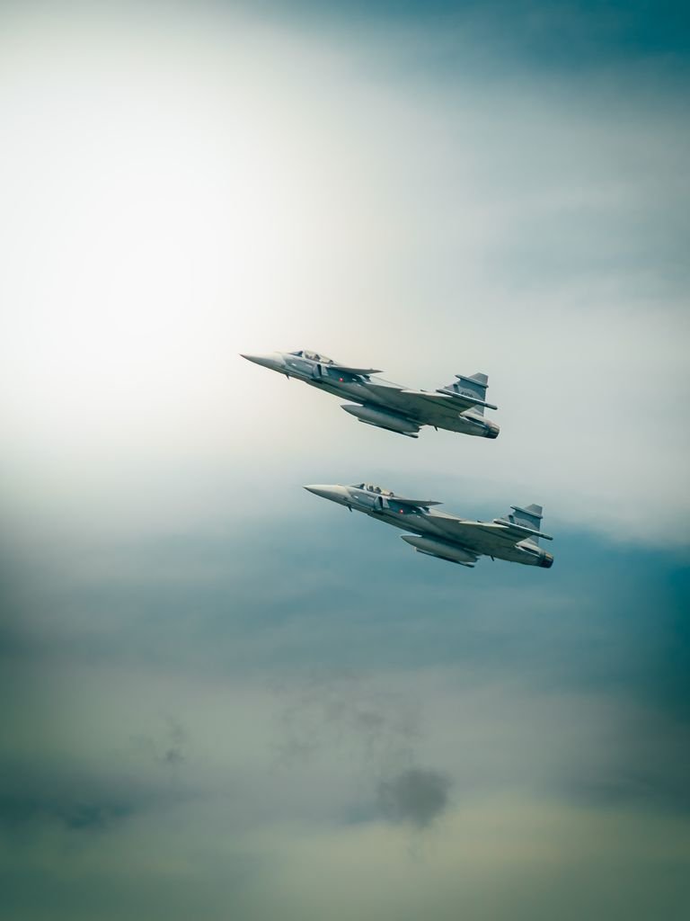 Two military jets soaring through the sky, showcasing precision and speed.