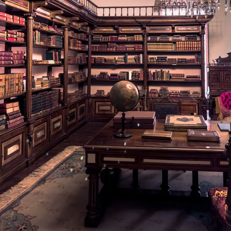 Elegant antique library filled with books and a globe on a wooden table, showcasing classic style.